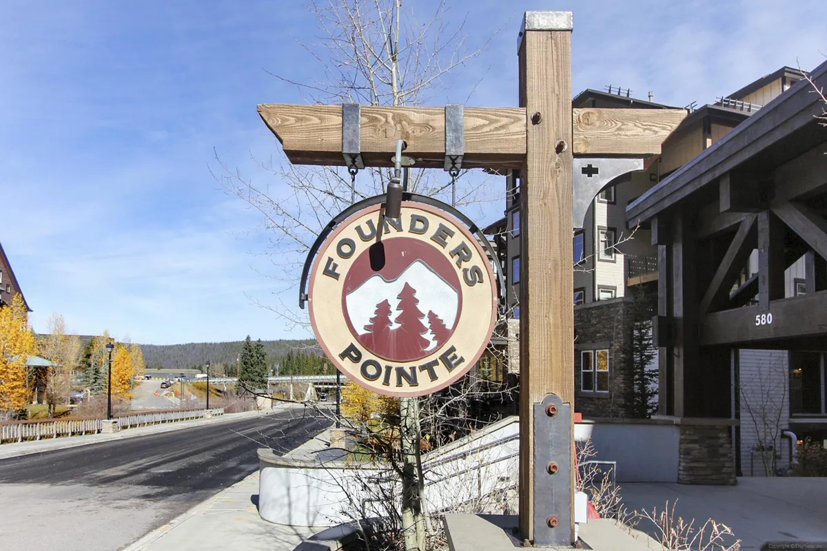 The Founder's Pointe sign sits amidst trees and the building structure, representing a welcoming entry point to the property and the gateway to nearby outdoor activities like hiking and community gatherings.