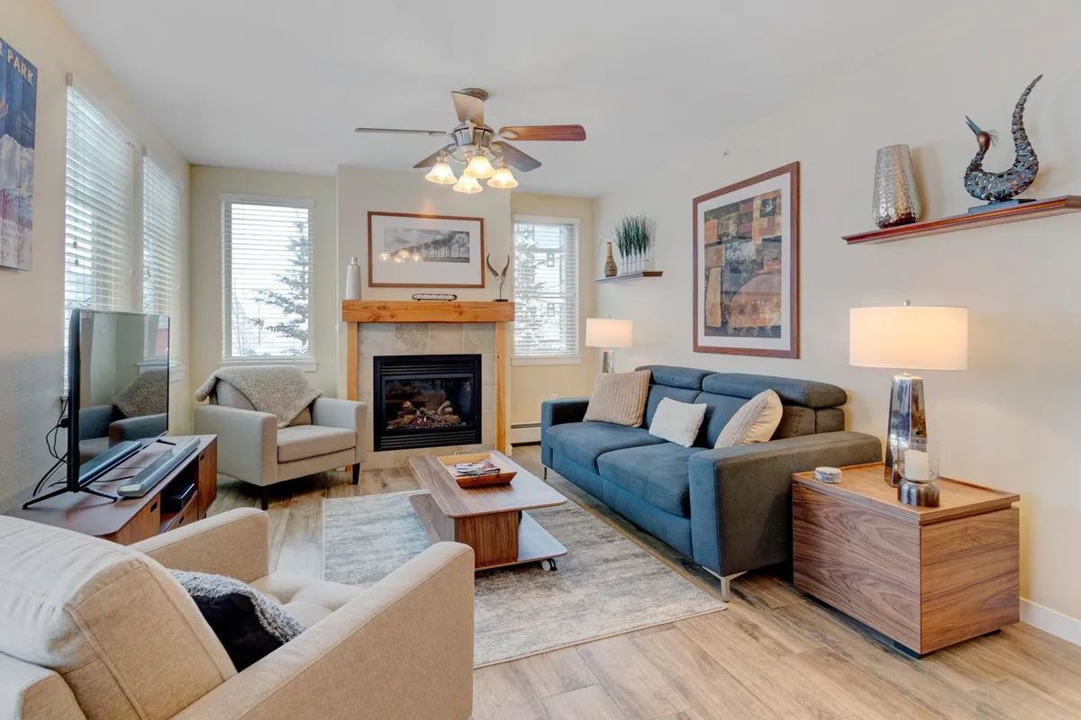 A cozy, welcoming interior living area centered around a modern fireplace, with a plush sofa and a coffee table—an inviting space for family gatherings, playing board games, or relaxing after a day of excitement. Warm lighting and tasteful artwork contribute to a comfortable ambiance.